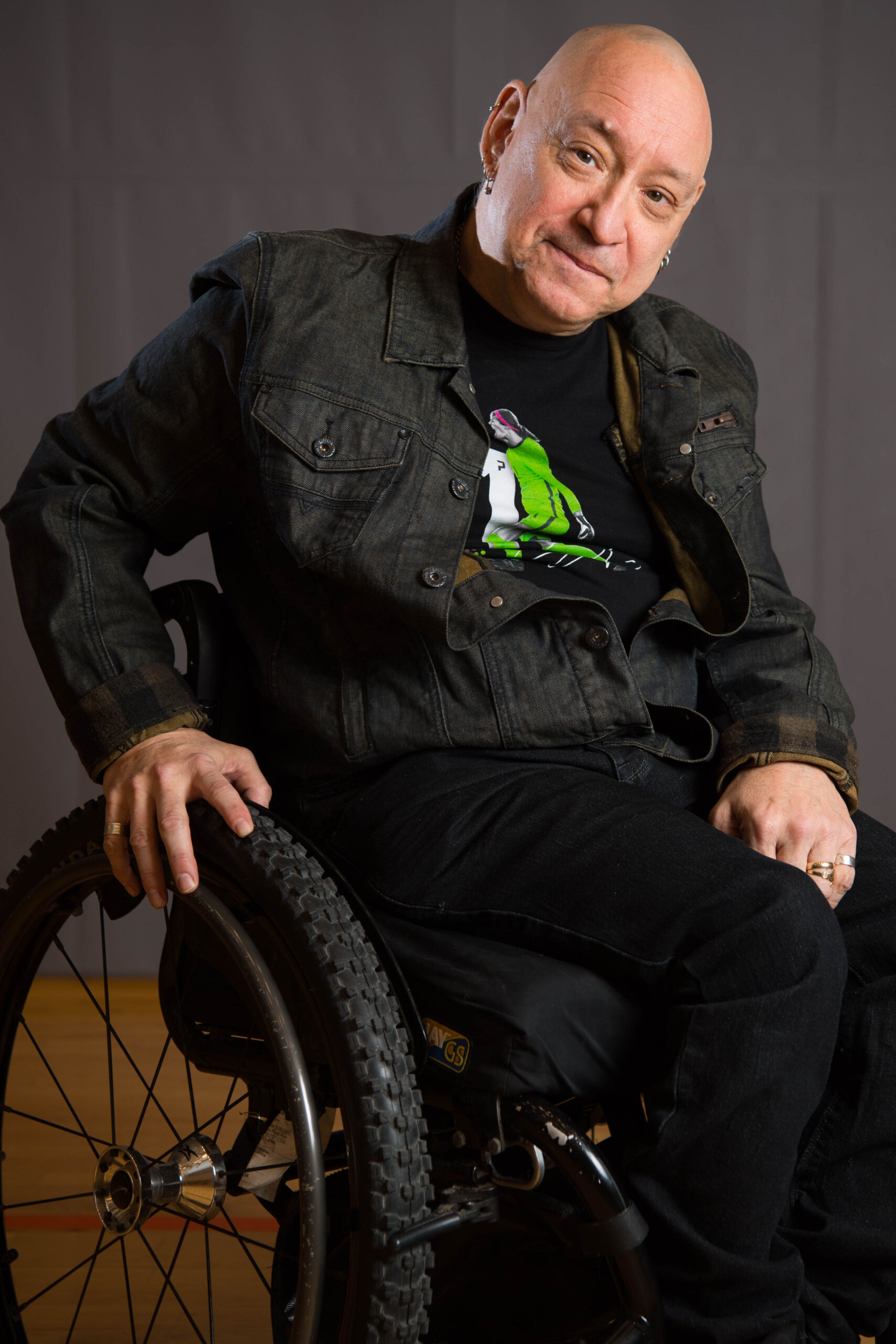 Man wearing black jacket, sitting in wheelchair.